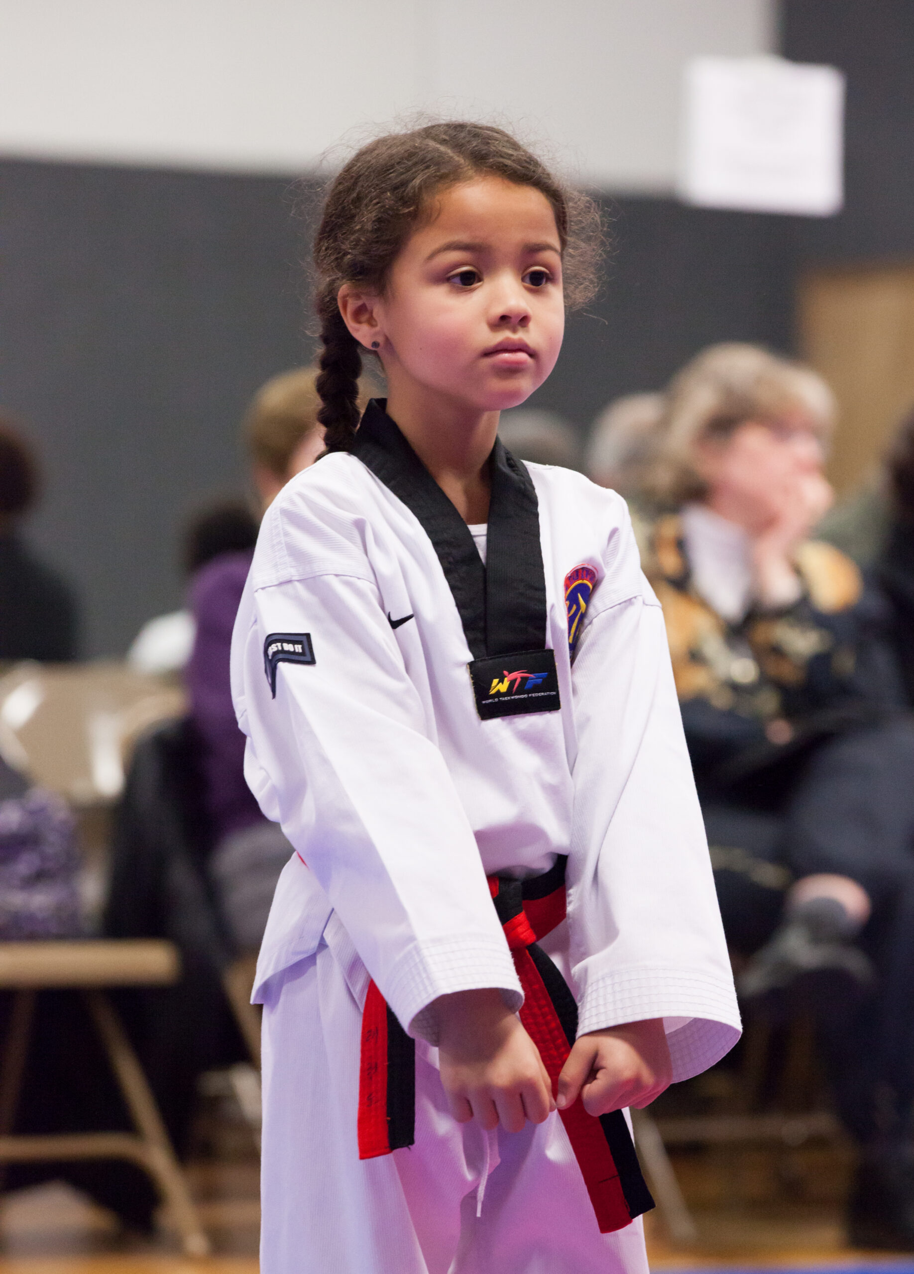 young girl in white gi standing alone